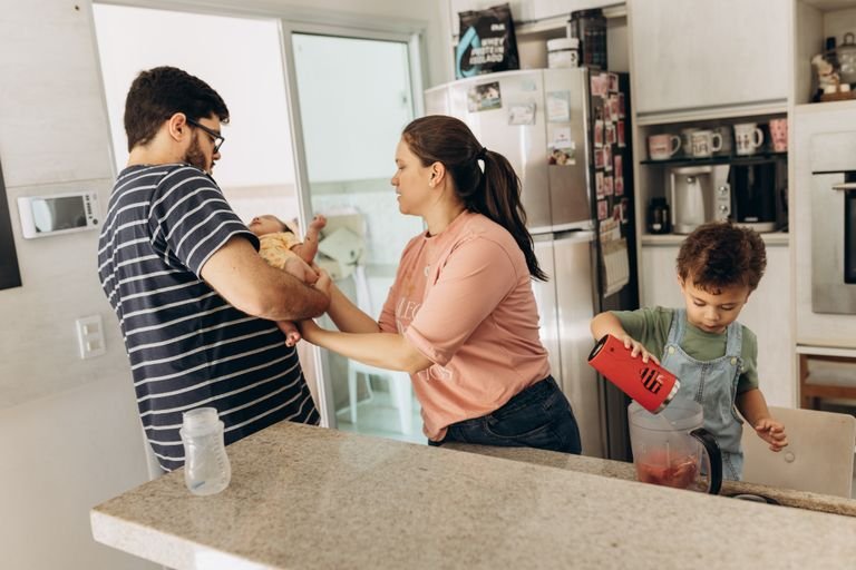 Family in a kitchen with parents and children engaged in daily activities together.